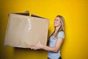Woman Moving Box to illustrate how to choose a reputable moving company