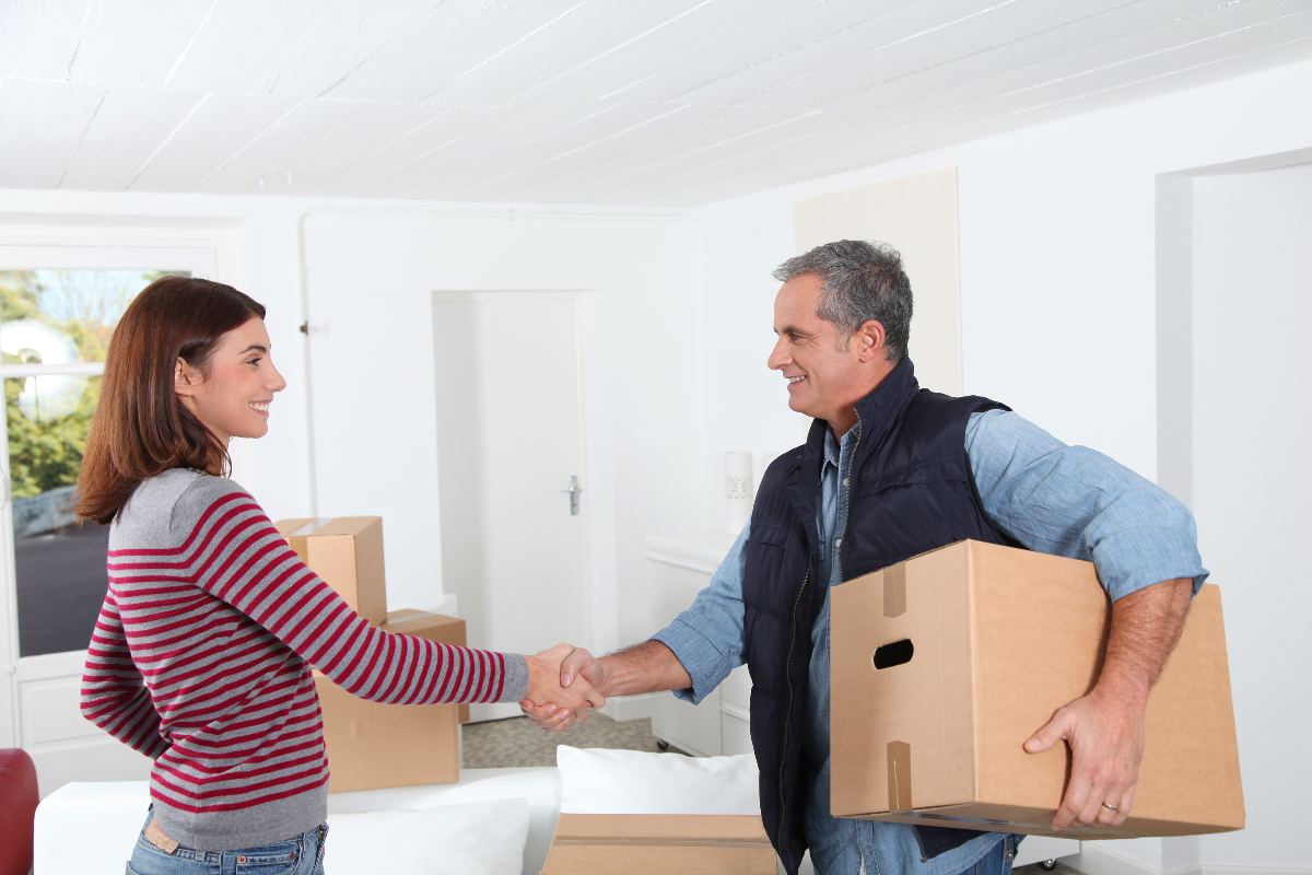 Young woman shaking hands with a mover to help illustrate do you tip home movers