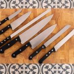 A set of kitchen knives on a cutting board to illustrate how to pack knives for moving