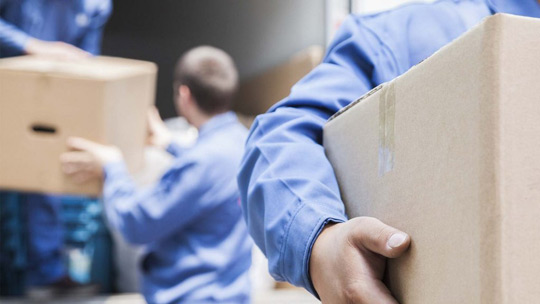 Moving Company Portland | blue movers carrying boxes to illustrate packing companies near me