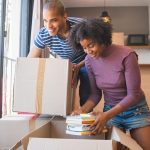 Young black couple unpacking at their new house to illustrate Questions To Ask Movers And Packers
