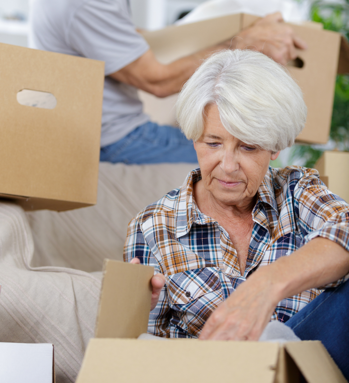 Senior woman unpacking boxes in a retirement home.