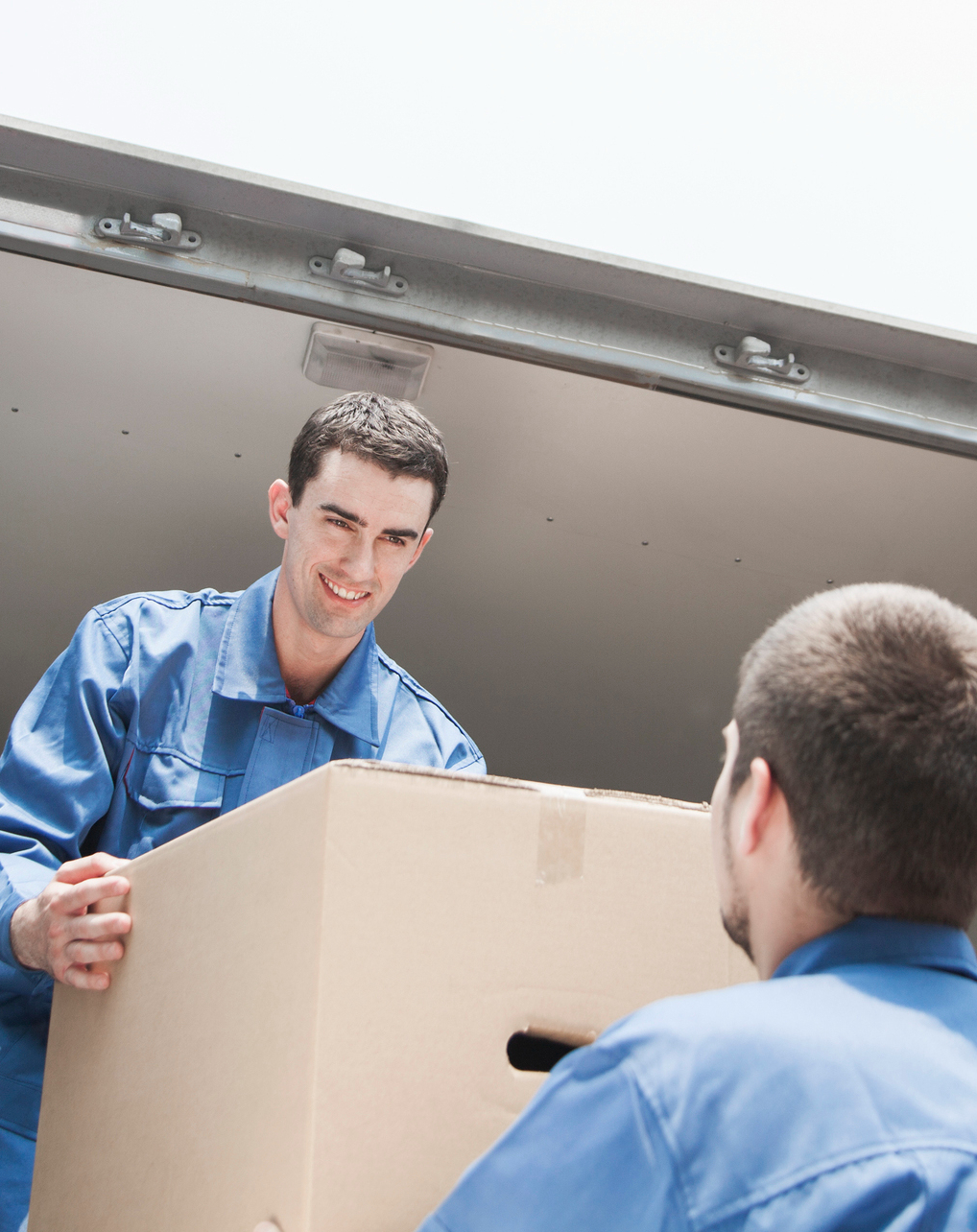 two-movers-and-a-truck Two movers unloading a truck to help illustrate low moving rates.